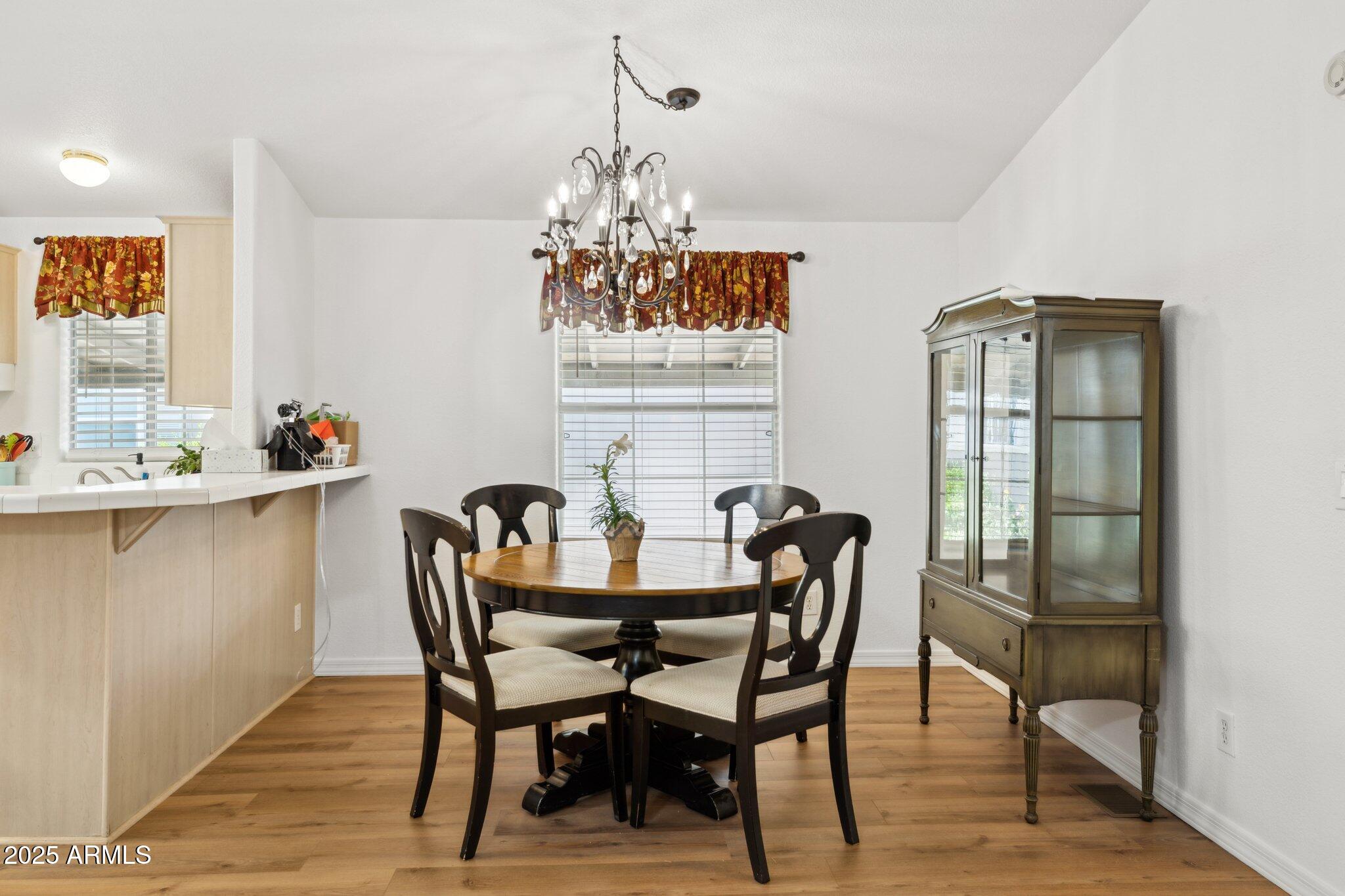 3901 East Pinnacle Peak Road, Unit 105 Phoenix, AZ 85050 - Photo 6 of 23 a dining room with furniture a chandelier and wooden floor