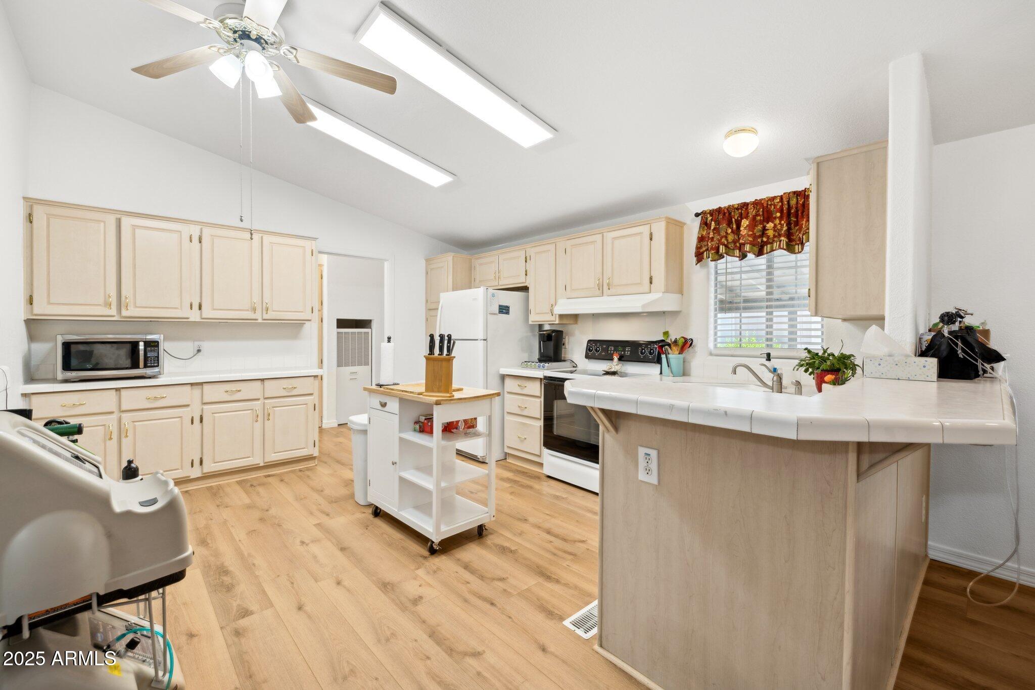 3901 East Pinnacle Peak Road, Unit 105 Phoenix, AZ 85050 - Photo 7 of 23 a kitchen with white cabinets and appliances