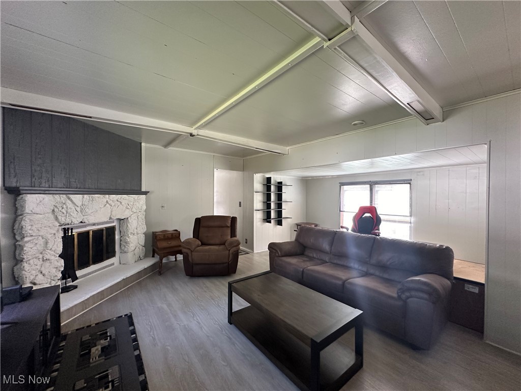 5852 Cleveland Road, Unit 21 Wooster, OH 44691 - Photo 5 of 17 Living room featuring a stone fireplace, wooden walls, and hardwood / wood-style flooring