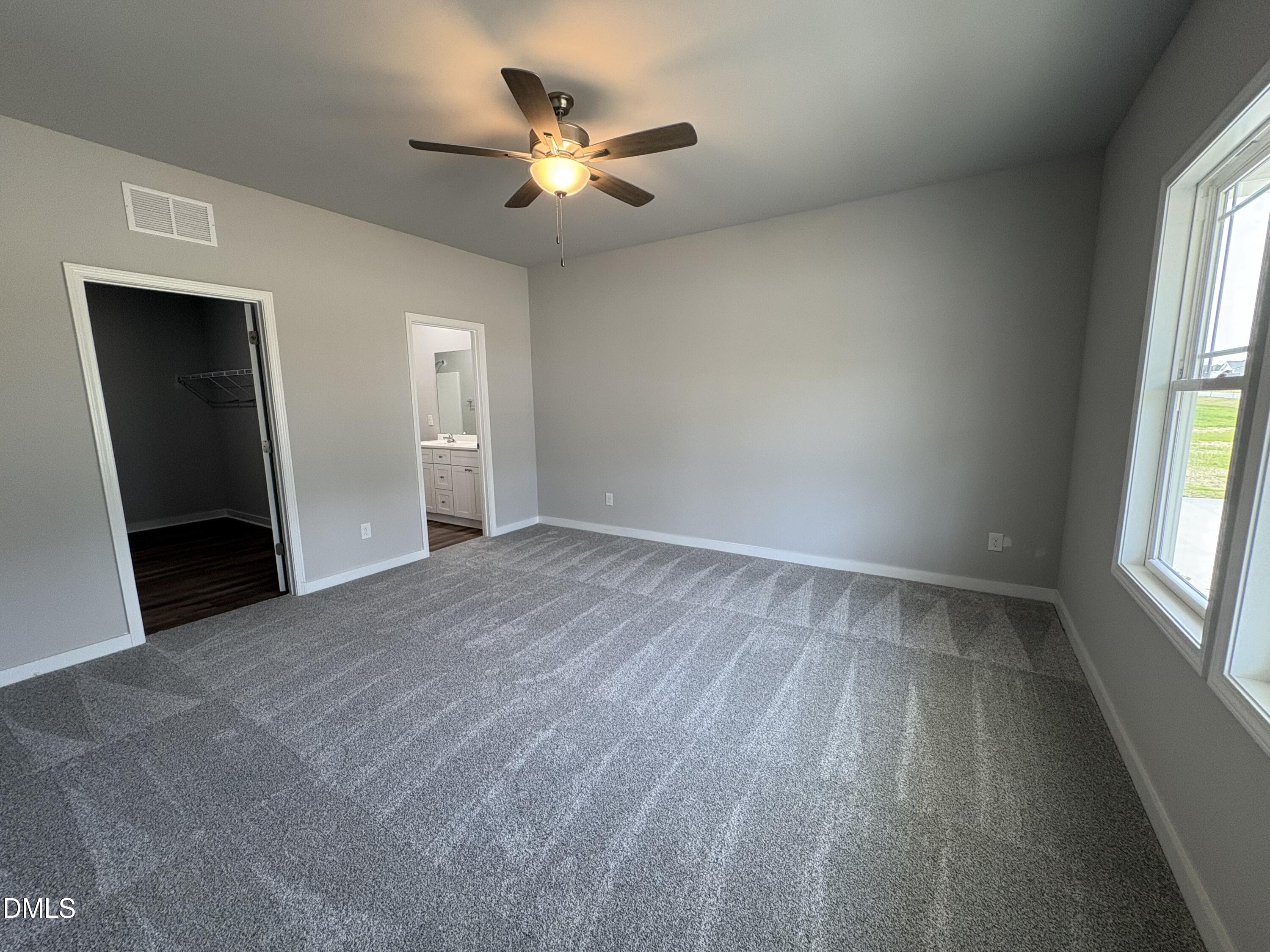 274 Jacobs Ridge Drive Four Oaks, NC 27524 - Photo 7 of 14 an empty room with windows and fan