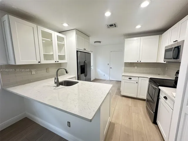a kitchen with a sink a stove a refrigerator and cabinets