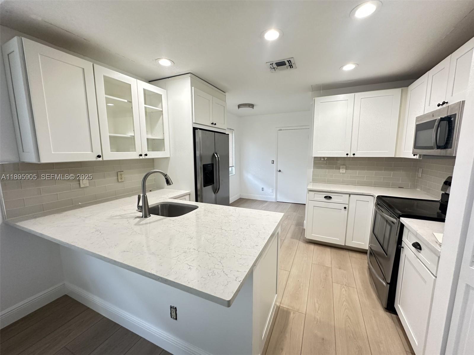 a kitchen with a sink a stove a refrigerator and cabinets