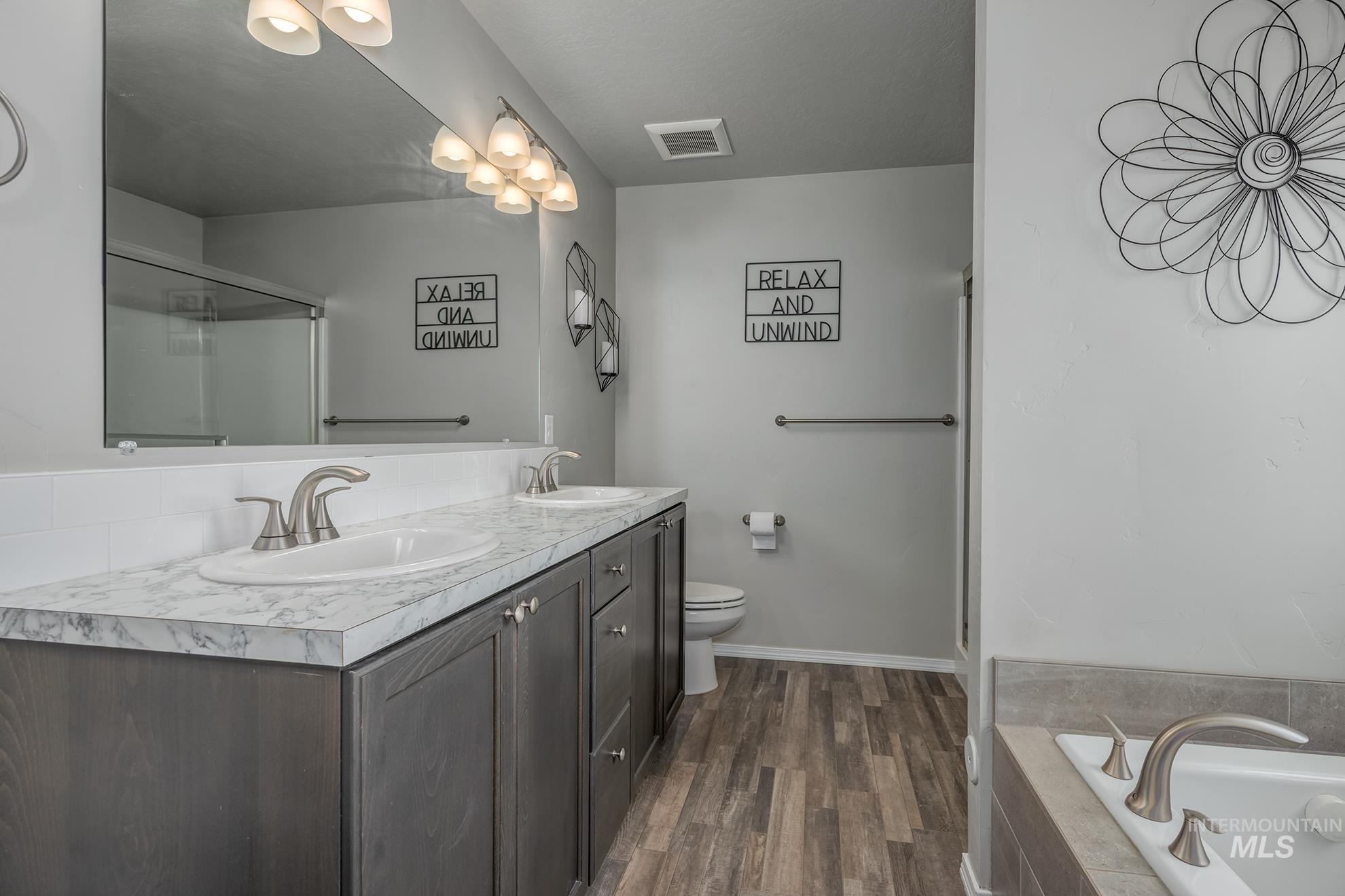 1049 Price Road Weiser, ID 83672 - Photo 16 of 47 Dual vanity with wood-finish cabinetry, white countertop, and integrated sinks