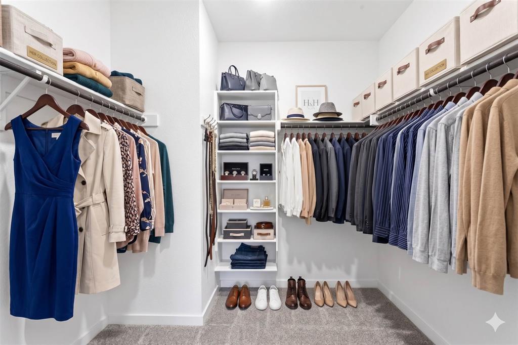656 Waymaker Way Princeton, TX 75407 - Photo 10 of 40 Custom-designed walk-in closet featuring extensive hanging space, built-in shelving, white walls, and soft gray carpeting