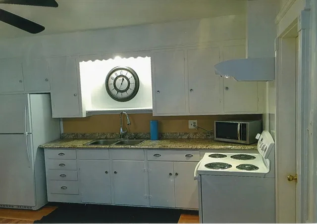 a kitchen with stainless steel appliances granite countertop a refrigerator a stove and a sink