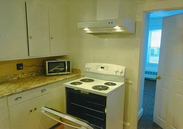 a kitchen with granite countertop cabinets stainless steel appliances and wooden floor