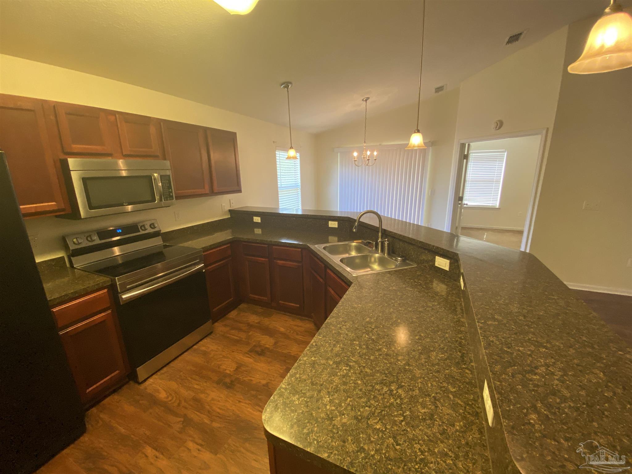 2189 Liberty Loop Road Cantonment, FL 32533 - Photo 17 of 25 a kitchen with granite countertop sink and cabinets