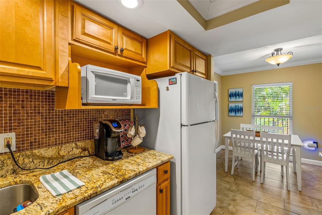 8911 Blind Pass Road, Unit 223 St. Pete Beach, FL 33706 - Photo 12 of 29 a kitchen with stainless steel appliances granite countertop a refrigerator and a stove