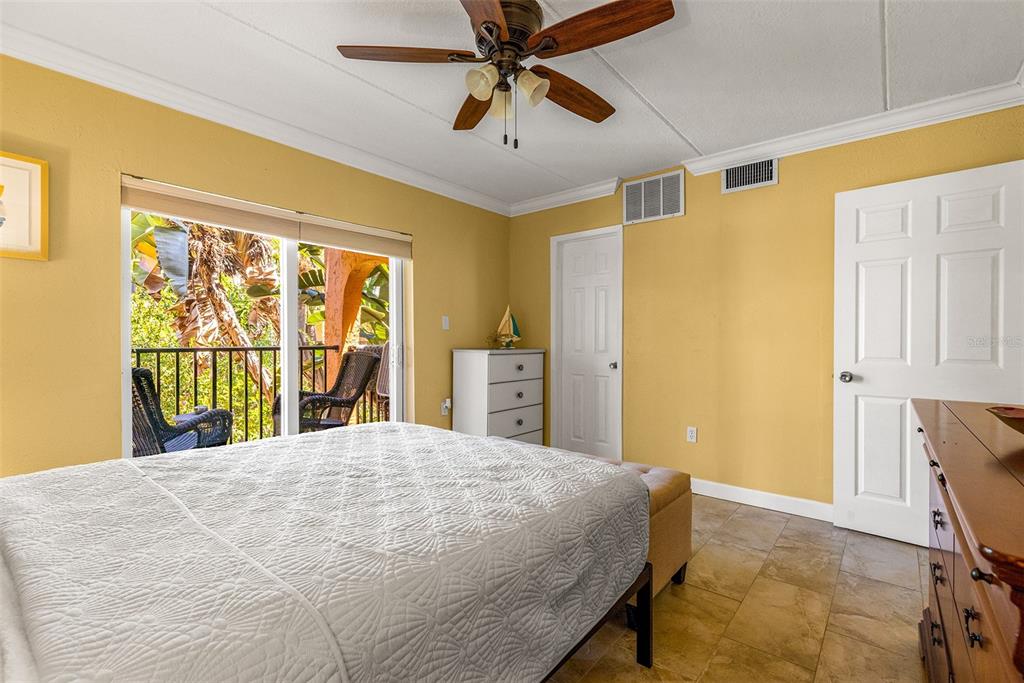 8911 Blind Pass Road, Unit 223 St. Pete Beach, FL 33706 - Photo 18 of 29 a bedroom with a bed and a chandelier