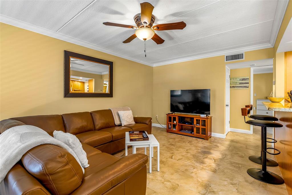 8911 Blind Pass Road, Unit 223 St. Pete Beach, FL 33706 - Photo 6 of 29 a living room with furniture and a flat screen tv