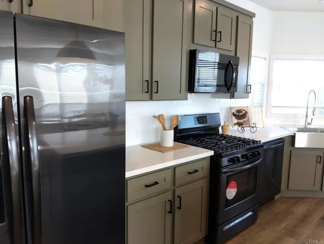 a kitchen with stainless steel appliances granite countertop a stove a sink and a refrigerator