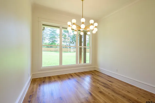 a view of a room with wooden floor and chandelier