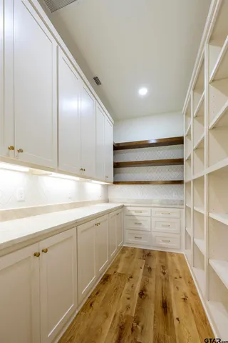 a view of storage and utility room with wooden floor