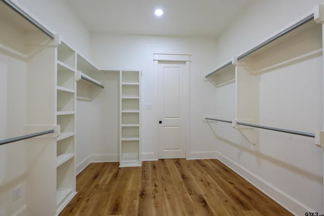 a view of a closet with wooden floor