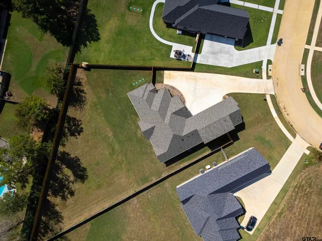 a view of a white house with a yard and potted plants