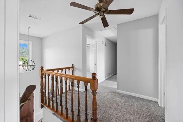a view of a hallway with wooden floor and stairs