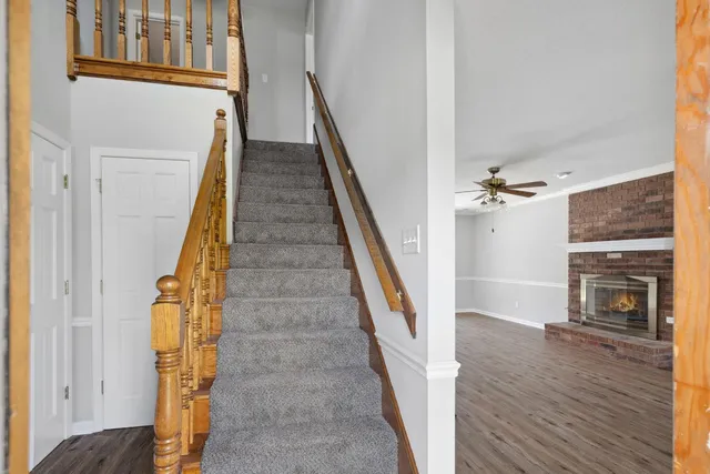 a view of a hallway with wooden floor and staircase