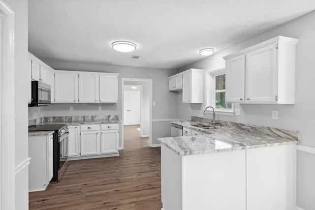 a kitchen with stainless steel appliances granite countertop a stove sink and cabinets