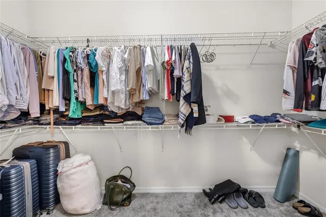 a view of walk in closet with clothes and shoes