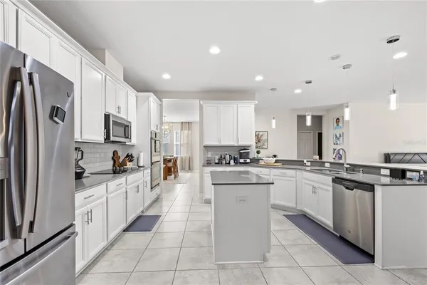 a kitchen with stainless steel appliances granite countertop a refrigerator and a stove top oven