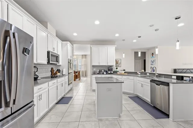 a kitchen with stainless steel appliances granite countertop a refrigerator and a stove top oven