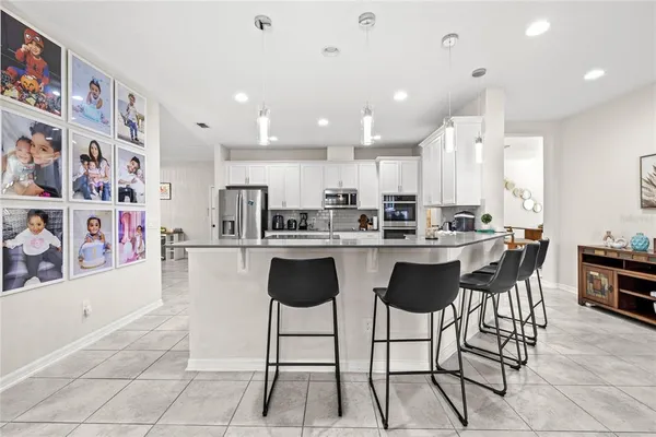 a kitchen with stainless steel appliances kitchen island granite countertop a table and chairs