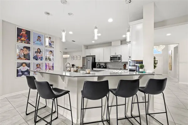 a kitchen with a dining table chairs cabinets and stainless steel appliances