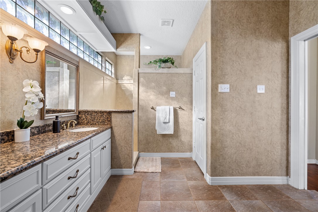 2250 Dillard Road Washington, TX 77880 - Photo 18 of 50 a bathroom with a granite countertop sink a mirror and a shower