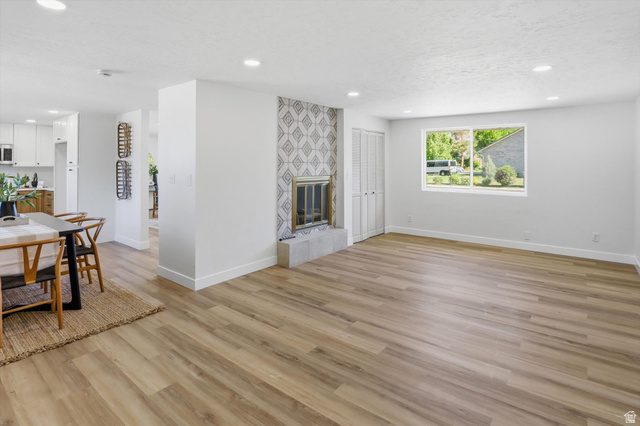 810 East Maple Street Mapleton, UT 84664 - Photo 15 of 49 Spacious living area featuring wood-finish flooring, recessed lighting, and a fireplace with a decorative tile surround and stone hearth