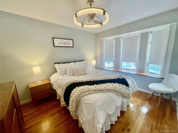 a bedroom with a bed and a lamp with the wooden floor