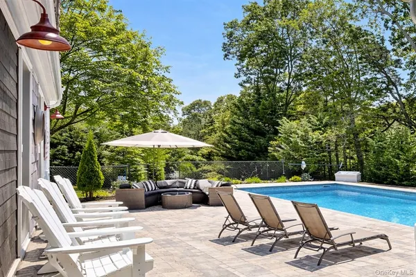 a view of a patio with a table and chairs under an umbrella