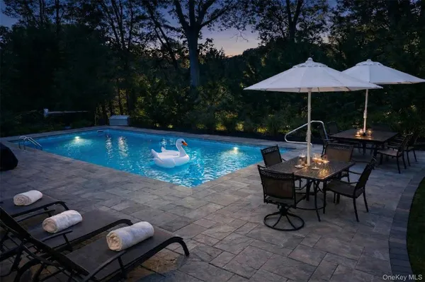 a view of patio with chairs and table under an umbrella