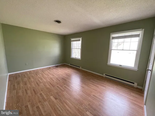 a view of a hallway with wooden floor and stairs