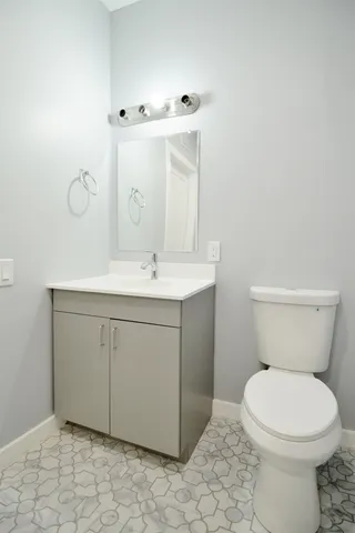 a bathroom with a sink a toilet and mirror