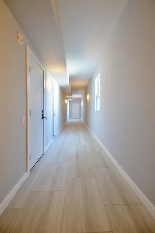 a view of a hallway with wooden floor