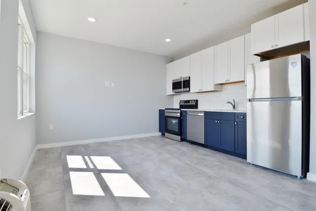 a kitchen with stainless steel appliances a refrigerator and a stove top oven