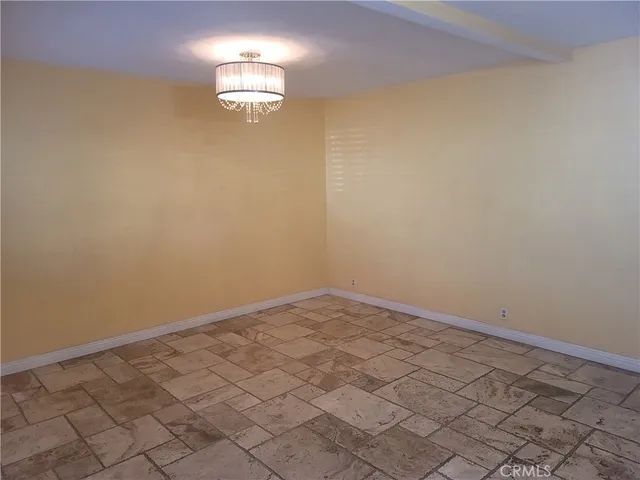 an empty room with a bench and a potted plant
