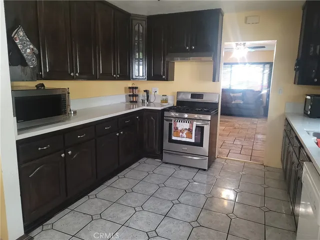 a kitchen with stainless steel appliances a sink stove top oven and cabinets