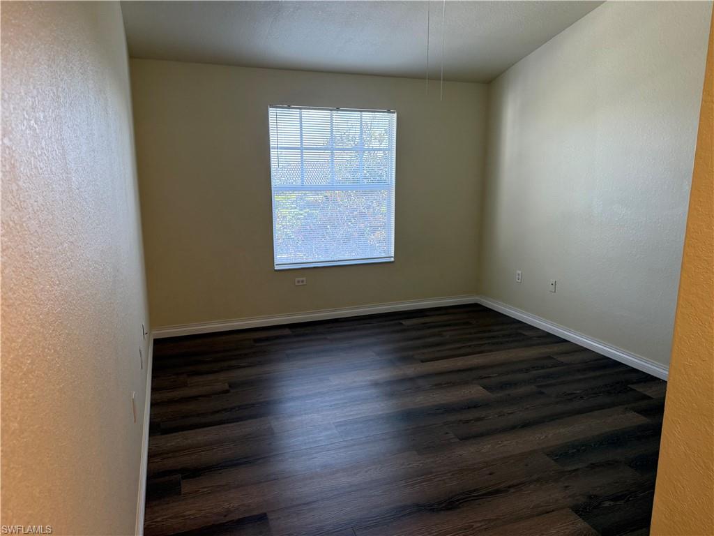 7985 Preserve Circle, Unit 1133 Naples, FL 34119 - Photo 17 of 36 an empty room with wooden floor and windows