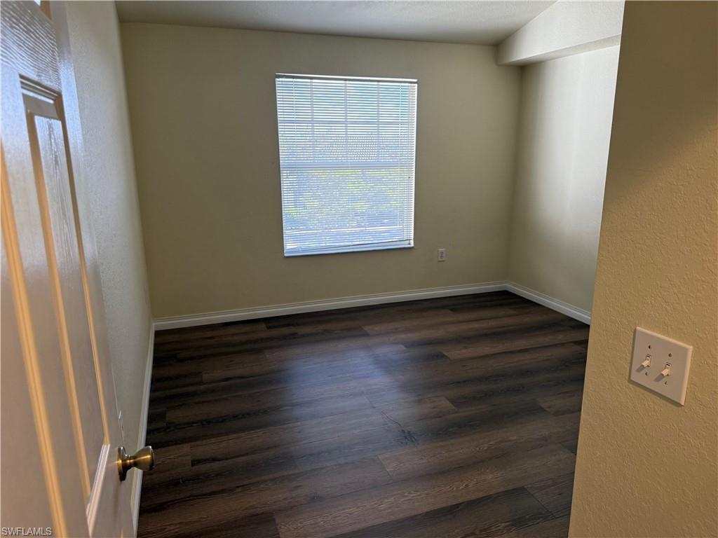 7985 Preserve Circle, Unit 1133 Naples, FL 34119 - Photo 24 of 36 a view of an empty room with wooden floor and a window