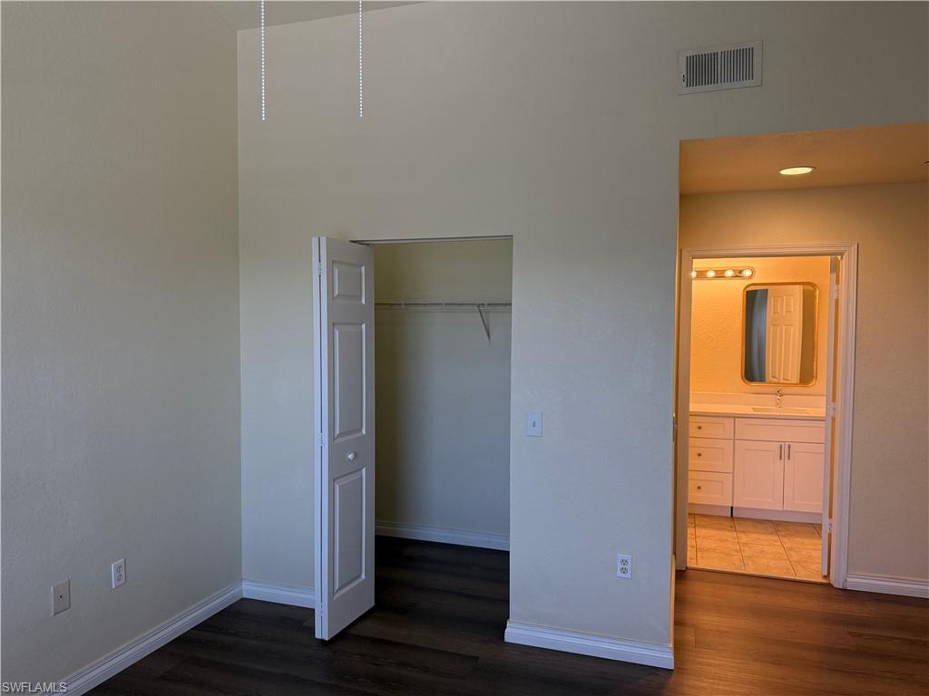 7985 Preserve Circle, Unit 1133 Naples, FL 34119 - Photo 31 of 36 an empty room with wooden floor and windows