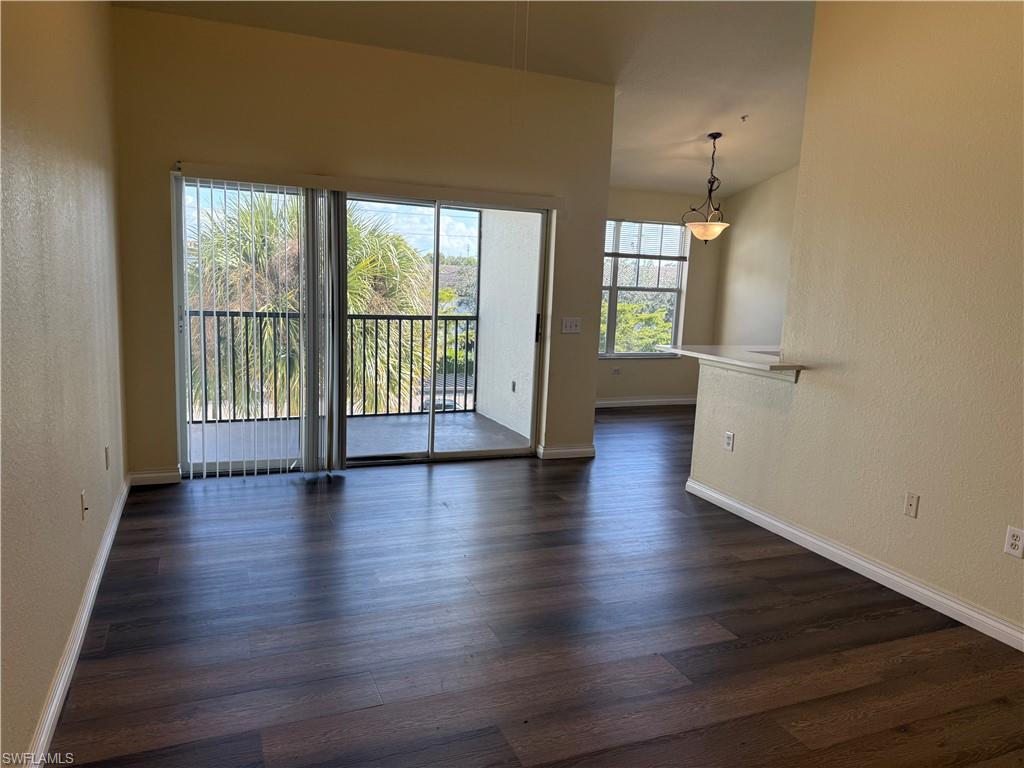 7985 Preserve Circle, Unit 1133 Naples, FL 34119 - Photo 5 of 36 an empty room with wooden floor and large window