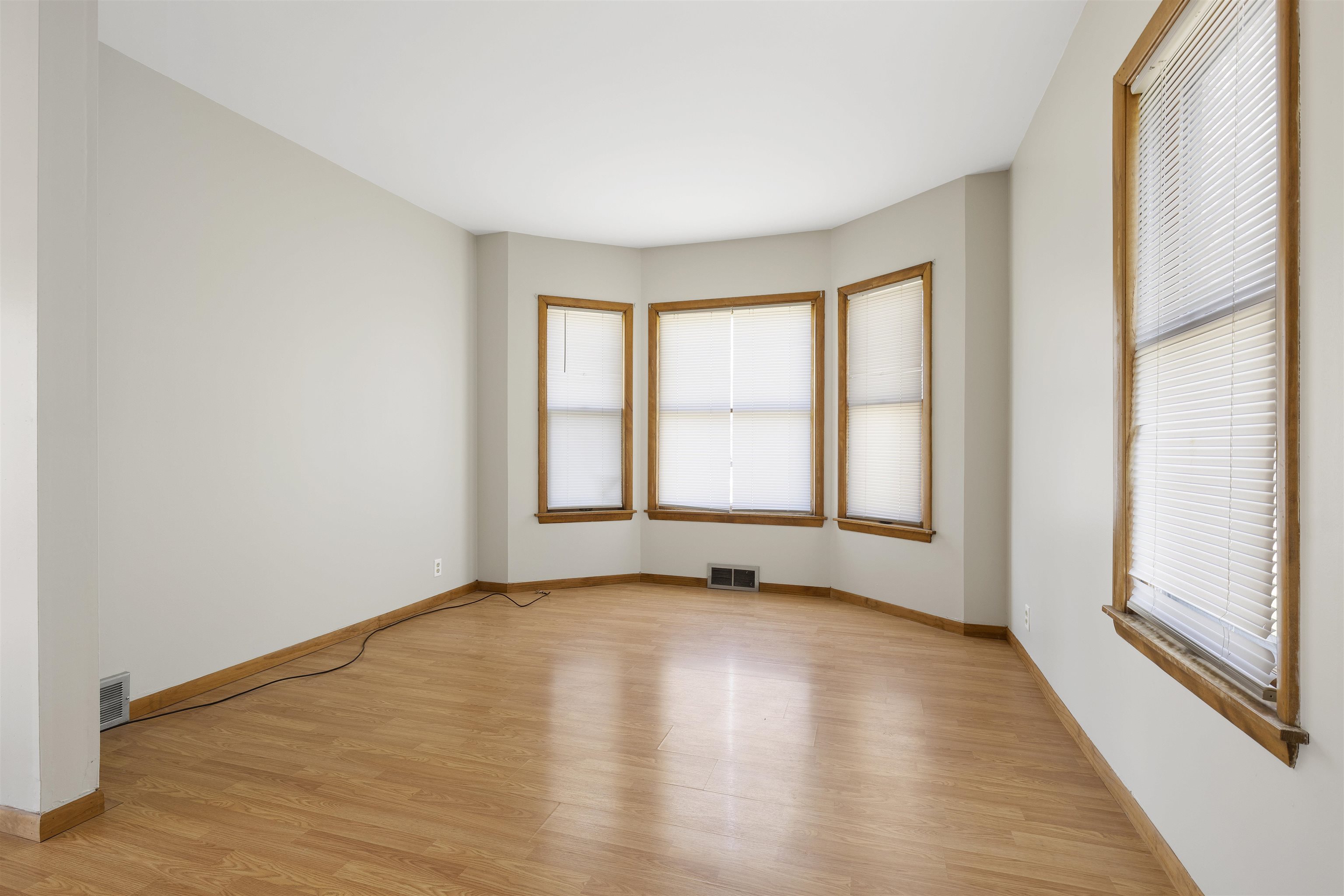703 North Main Street Rochelle, IL 61068 - Photo 5 of 21 a view of an empty room with a window and wooden floor