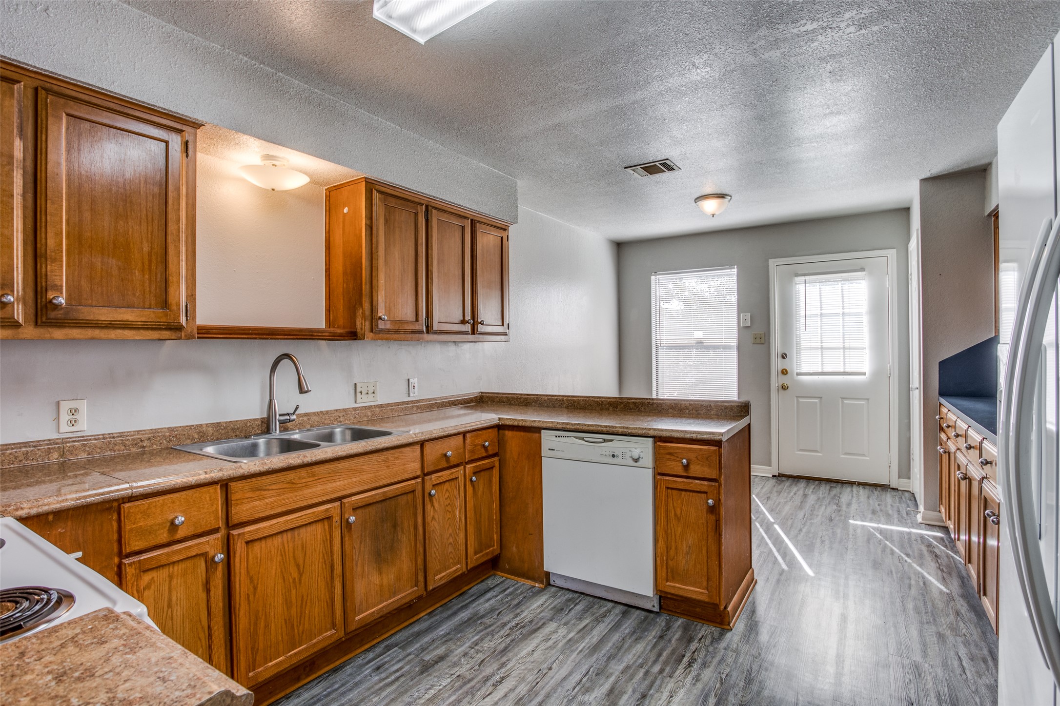 106 Verna Spur, Unit B Georgetown, TX 78628 - Photo 8 of 25 Functional kitchen with ample cabinet space, a practical layout, and direct outdoor access.
