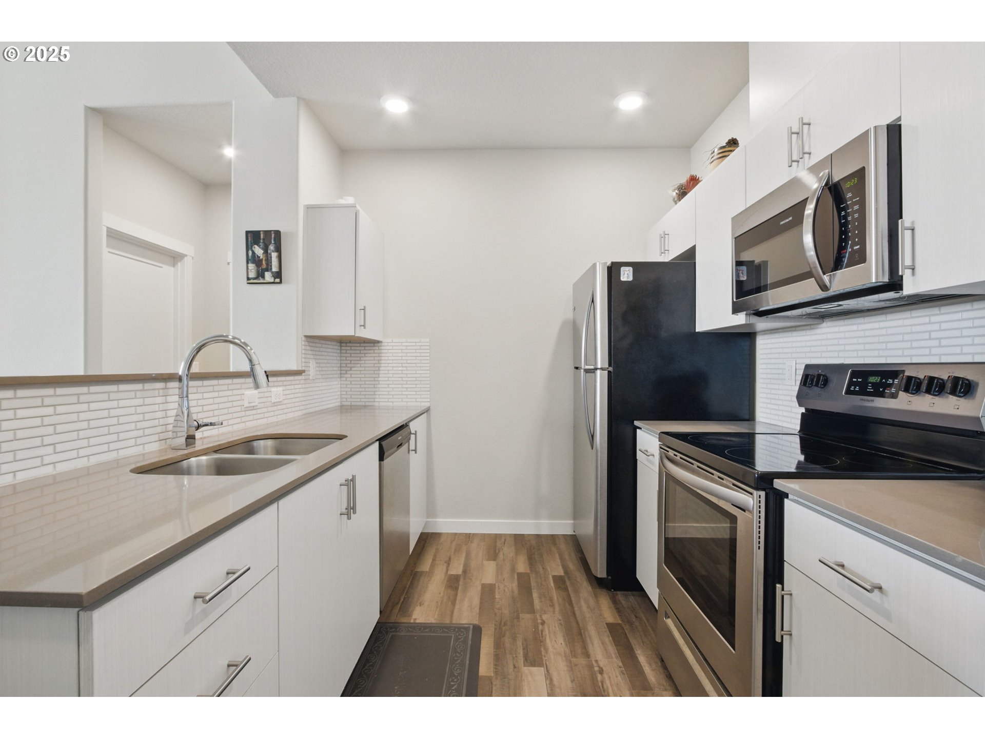 16322 Northwest Chadwick Way, Unit 303 Portland, OR 97229 - Photo 7 of 23 a kitchen with stainless steel appliances granite countertop a sink stove and refrigerator