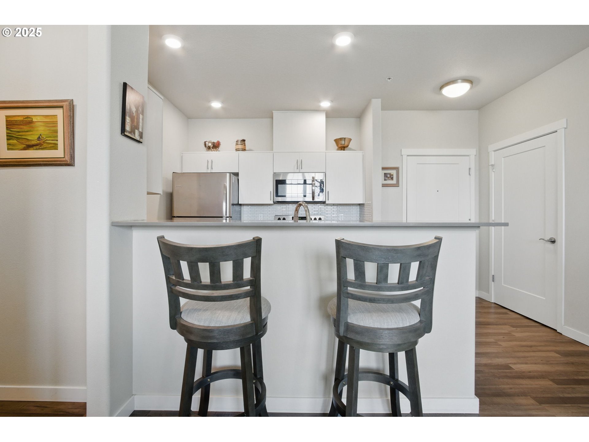 16322 Northwest Chadwick Way, Unit 303 Portland, OR 97229 - Photo 8 of 23 a kitchen with kitchen island a table and chairs