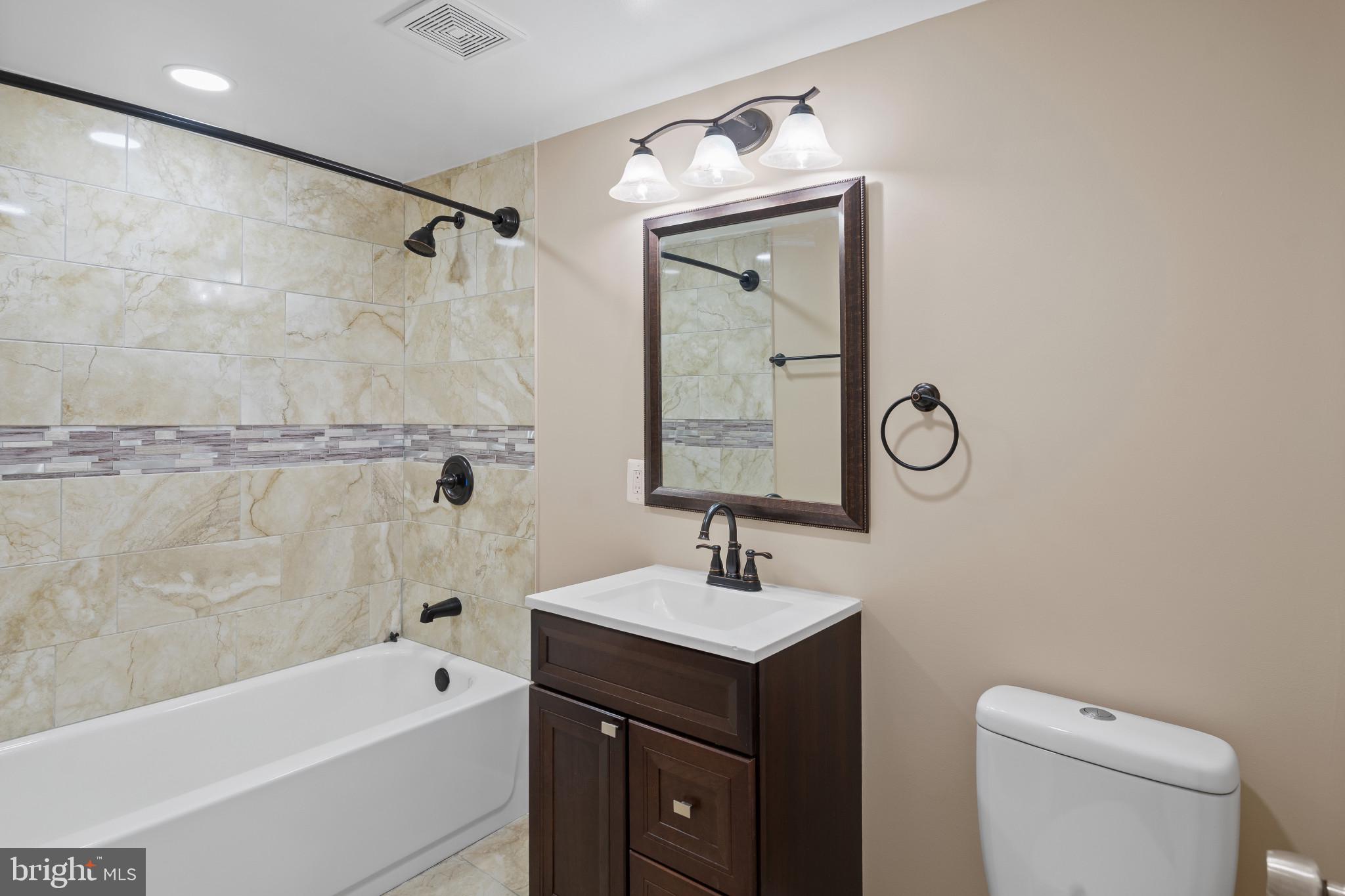 712 Kent Avenue Baltimore, MD 21228 - Photo 22 of 30 a bathroom with a toilet sink shower and mirror