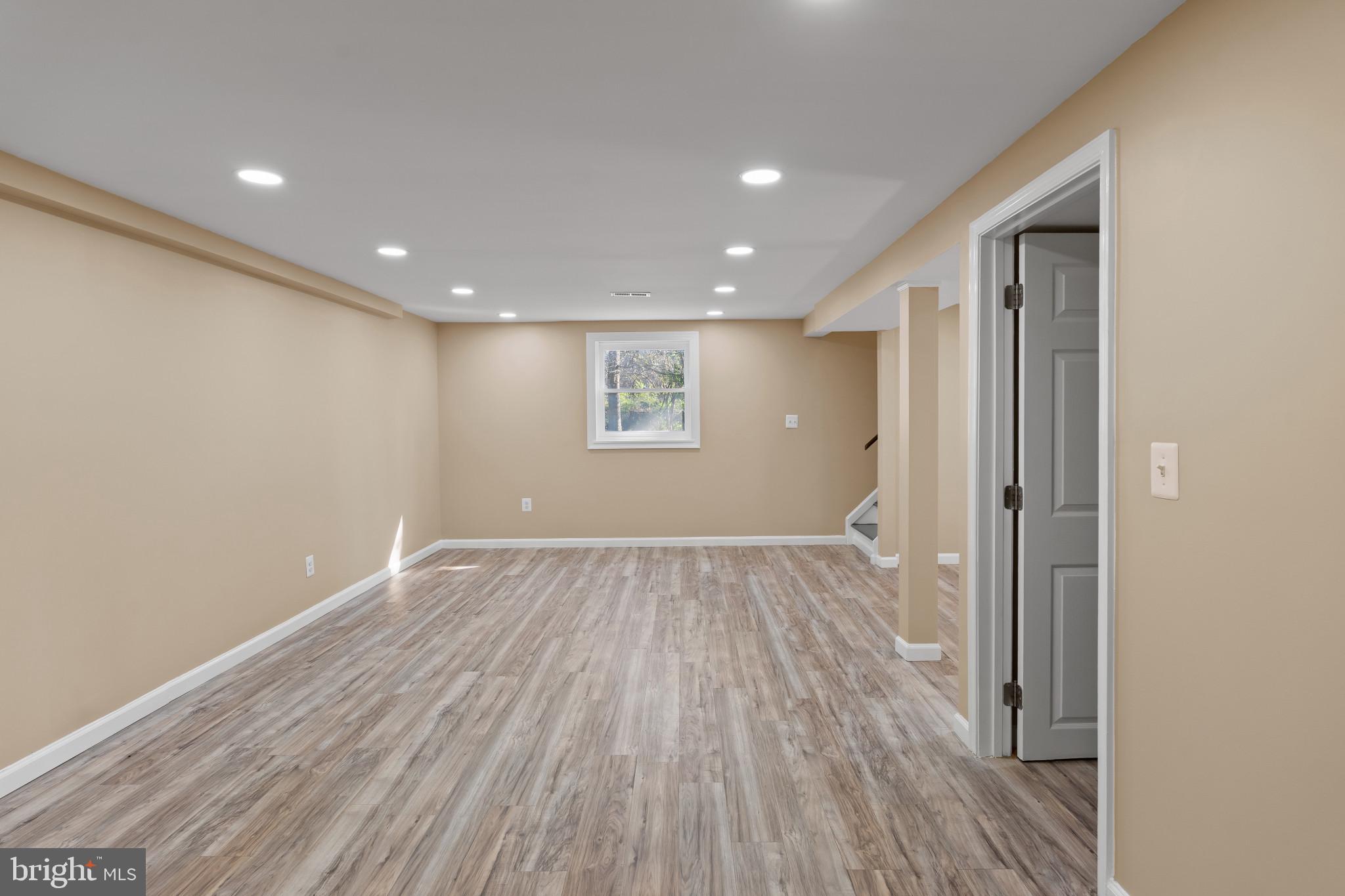 712 Kent Avenue Baltimore, MD 21228 - Photo 26 of 30 a view of an empty room with wooden floor and a window