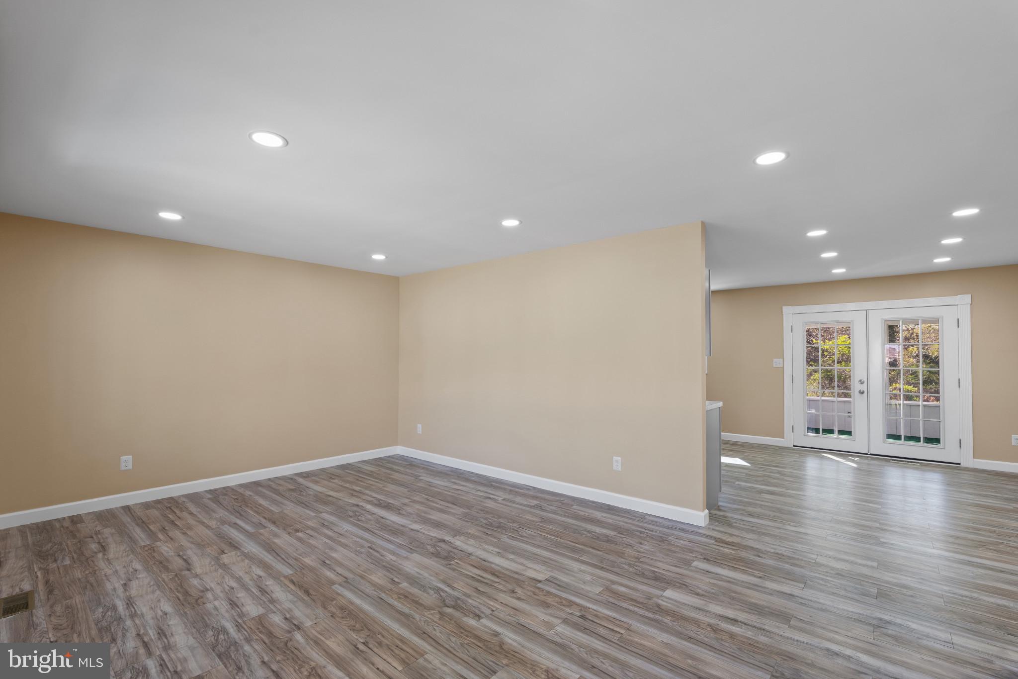 712 Kent Avenue Baltimore, MD 21228 - Photo 5 of 30 a view of an empty room with wooden floor and a window