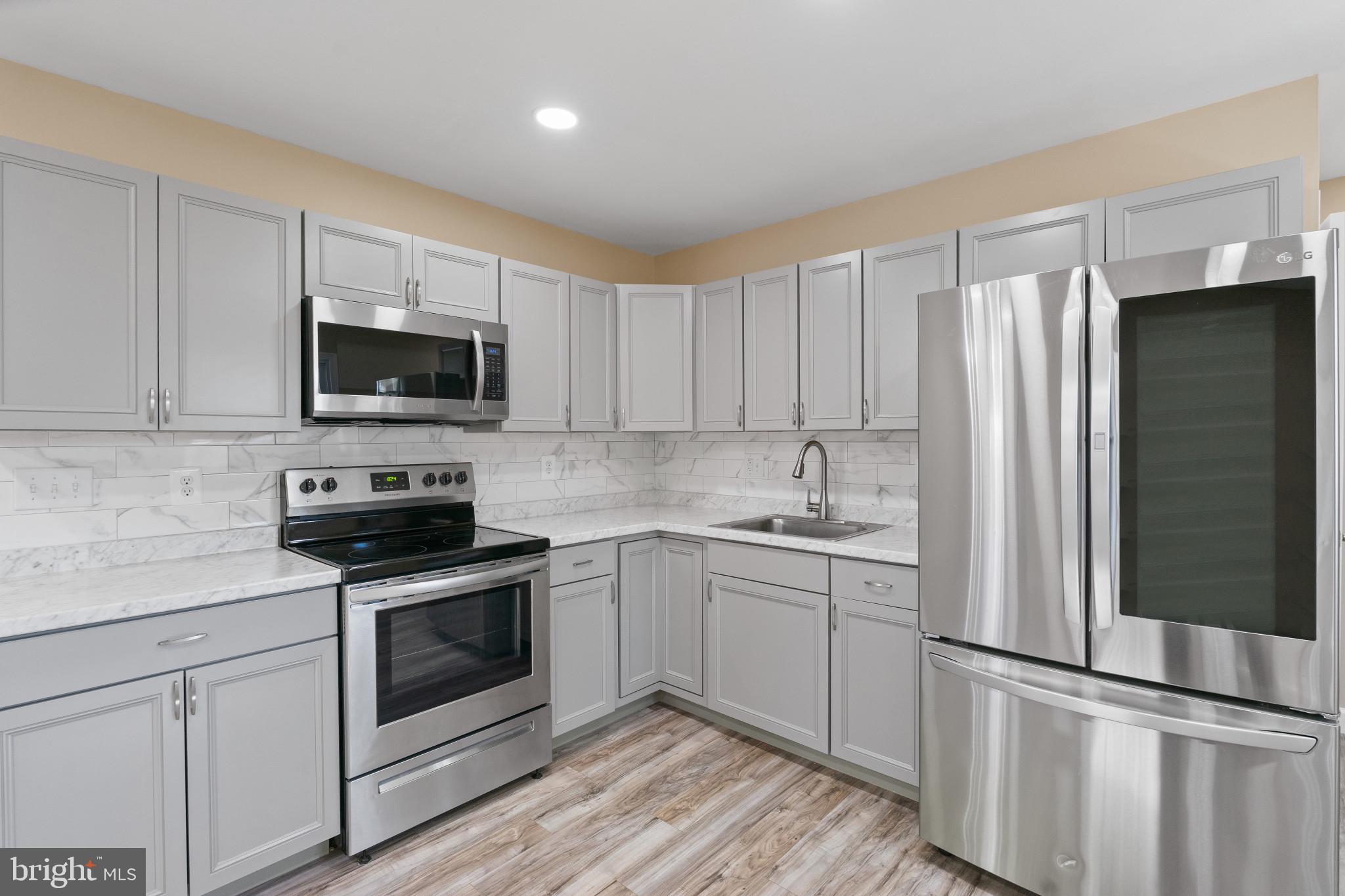 712 Kent Avenue Baltimore, MD 21228 - Photo 9 of 30 a kitchen with appliances a sink and cabinets